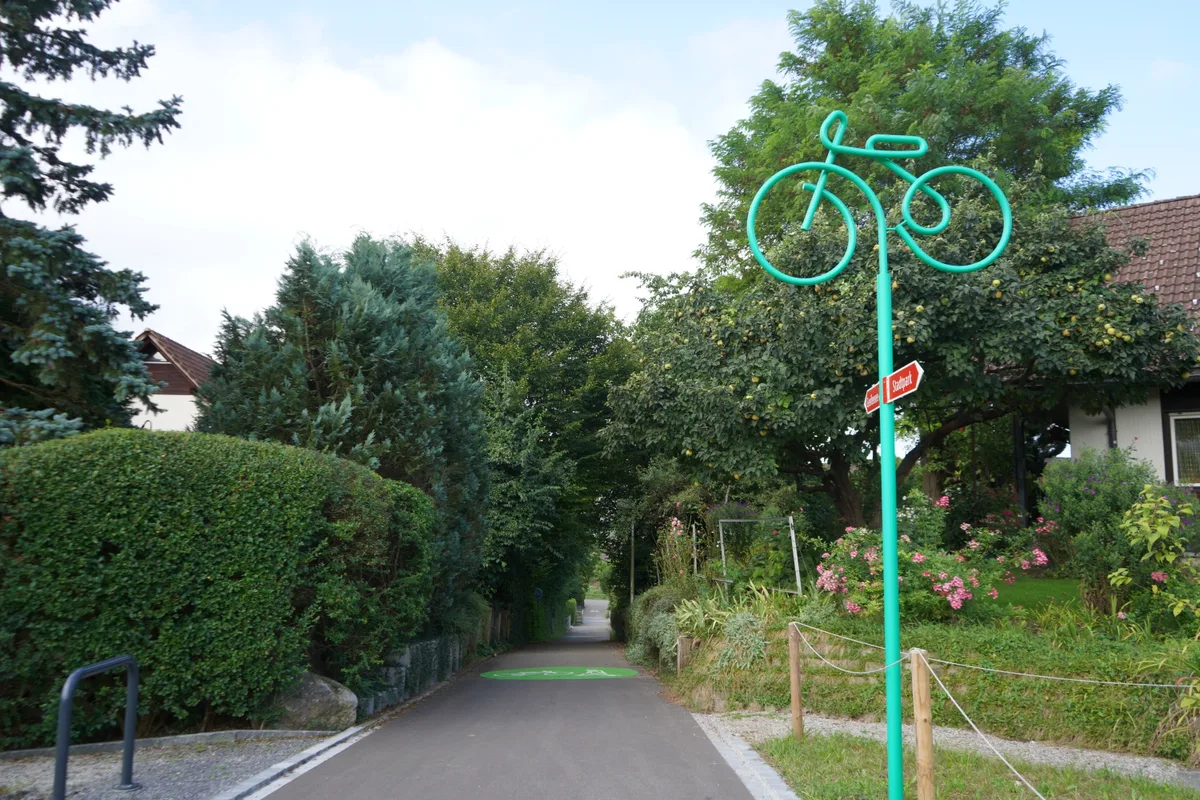 «Uster steigt um!»: grüne Markierung auf dem Boden mit einem Fahrrad und einem Fussgänger.